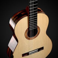 a close up of an acoustic guitar on a black background with the fret section missing