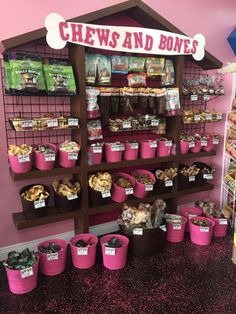 the shelves are filled with many different types of treats and snacks in pink buckets