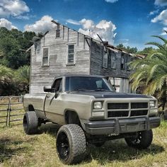 an old pick up truck parked in front of a house with a ladder on it