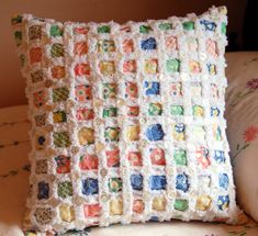 a crocheted pillow sitting on top of a bed