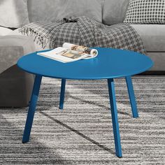 a blue coffee table sitting on top of a carpeted floor next to a couch