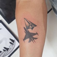 a small airplane tattoo on the arm