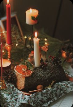 a table topped with candles and sliced oranges