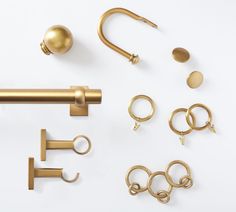 an assortment of brass hardware and accessories on a white surface with clippings to the side