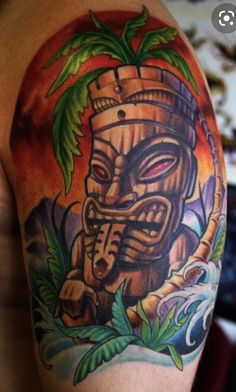 a man with a tiki tattoo on his arm and shoulder is shown in this image