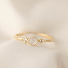 * Ring size: US 7 (Can be resized to US 5-8. Once the ring is resized down, it cannot be resized up more than 1/2 size) * 4mm Cabochon moonstone * Side stones: ≈1.5mm x2 G SI ethically sourced diamond * Band width: ≈2mm * Solid 14k yellow gold, rose gold and white gold. * Made of 100% recycled precious metal and ethically sourced gemstone. *Due to the nature of handmade pieces each jewelry might have slight variations. Colors may look slightly different depending on screen and lighting. Items mi Starburst Diamond Ring, Dainty Wedding Ring, Moon And Star Ring, June Birthday, Moonstone Engagement, Moonstone Engagement Ring, Three Stone Ring, Moon Ring, Dream Engagement Rings