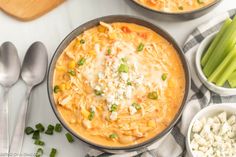 two bowls filled with pasta, cheese and celery on top of a table