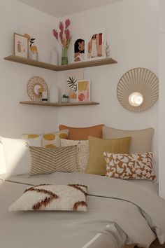 a bed with lots of pillows on top of it and shelves above the headboard