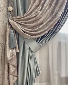 a curtain with tassels hanging from it's side in front of a window