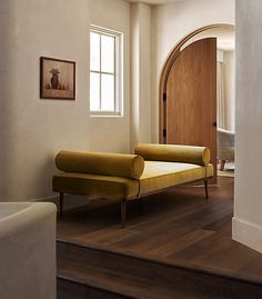 a living room filled with furniture next to a wooden door and window on top of a hard wood floor