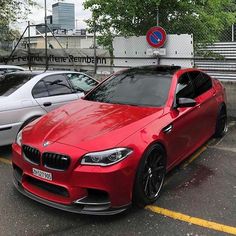 a red bmw is parked in the parking lot