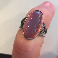 "This lovely vintage Sterling Silver ring has an oval shaped bezel set dragon's breath stone that is 3/4\" long. The sides have ornate heart shaped scrolls and the back is smooth and comfortable to wear, There is a very slight bend to one side of the band which is barely noticeable. Otherwise, this ring, which is a size 3 1/2, is in very good vintage condition. Please see all photos and feel free to ask any questions. Thank you for looking!" Antique Oval Opal Ring As Gift, Vintage Oval Cabochon Opal Ring Gift, Vintage Oval Cabochon Crystal Ring, Mystical Oval Cabochon Jewelry, Ornate Oval Cabochon Rings, Mystical Oval Cabochon Rings, Iridescent Oval Cabochon Ring, Filigree Diamond Ring, Heart Shaped Frame