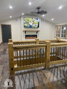 a living room with wood flooring and a flat screen tv mounted on the wall