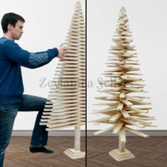 a man kneeling down next to a tall wooden christmas tree