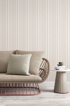 a couch and table in front of a striped wallpapered room with white flooring