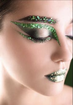 a woman with green glitter on her face and eye make - up is looking at the camera