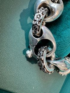 Express your individuality with this Sterling Silver Interlocking G Marina Chain Bracelet from Gucci. Adorned with a three-dimensional flower motif, this bracelet has a vintage look that will add a unique touch to your style. It is 21cm in length and features an antique-effect clasp and engraved details. Perfect for casual wear, this bracelet showcases the finest Italian craftsmanship. Shop our Jewellery Collection. Luxury Gucci Jewelry With Sterling Silver Clasp, Elegant Silver Gucci Bracelets, Designer Gucci Sterling Silver Jewelry, Gucci Sterling Silver Chain Jewelry, Luxury Vintage Sterling Silver Chain Bracelet, Chevron Outfit, Chevron Jewelry, Gucci Shop, Flat Wedges