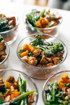 several bowls filled with food on top of a white countertop next to each other