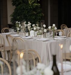 the table is set with white flowers and candles for an elegant dinner or party event