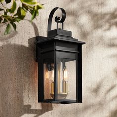 an outdoor wall light with two lights on it's side against a stucco wall