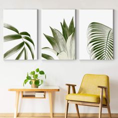 two green plants are on the wall next to a yellow chair and a small table