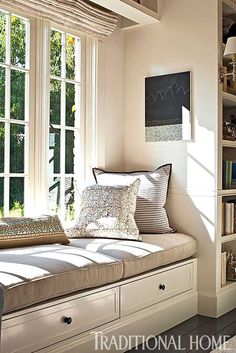 the sun shines through two large windows into a room filled with bookshelves