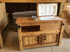 an ice chest made out of wooden planks with two drawers and one door open