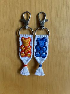 two crocheted key fobs are sitting on a table