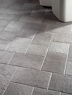 a white toilet sitting on top of a tiled floor