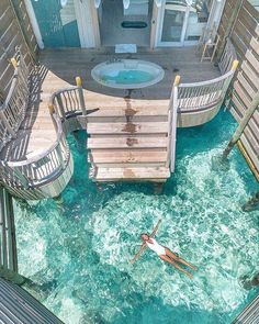 a person floating in the water next to some stairs