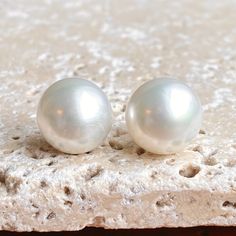 two white pearls sitting on top of a rock