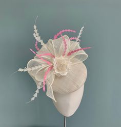 A beautiful ivory pillbox fascinator, with feathers and floral detailing. The perfect choice for Ascot, Kentucky Derby or a wedding. Made in ivory straw sinamay, this elegant fascinator features  a large double bow in ivory sinamay straw, and a delicate handmade silk dupion and organza multi petal rose that sits within the bow. The tail of the bow is slightly longer on one side, and twists gently down the side of the hat.  Scattered throughout the headpiece are chevron shaped coque feathers in i White Mini Hats For Royal Ascot, White Headpieces As A Spring Gift, White Headpieces For Spring Gift, White Fascinator For Kentucky Derby Gift, Cream Fascinator With Handmade Flowers For Races, Cream Fascinator With Handmade Flowers For Kentucky Derby, Cream Feathered Headpiece For Royal Ascot, Cream Fascinator For Kentucky Derby Ceremony, Cream Kentucky Derby Fascinator With Handmade Flowers