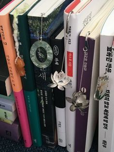 several books are stacked on top of each other with necklaces hanging from the book ends