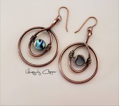 These copper earrings have been wire wrapped with an abalone shell bead in the in the center and have a drop length of 2 inches. They have been given an antiqued finish and then clear coated to protect them from tarnishing. They will make a perfect gift for her, as a 7th anniversary gift, copper anniversary, or 22nd anniversary gift. NOTE: These earrings are made to order, so please allow for slight variations in the center abalone shell bead. While they have been clear coated avoid water exposu Wire Jewelry Earrings, Wire Jewelry Patterns, Twist Jewelry, Wire Wrapped Stone Jewelry, Stone Bead Jewelry, Wire Wrap Jewelry Designs, Wire Wrapped Jewelry Diy, Copper Anniversary, Wire Jewelry Designs