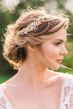 a woman wearing a gold leaf headpiece in her hair and looking off to the side