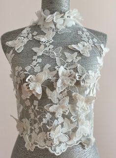 a mannequin with white lace and flowers on it