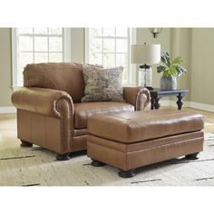 a brown chair and ottoman in a living room