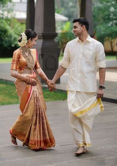 a man and woman holding hands walking down the street