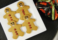 four decorated ginger cookies on a white plate