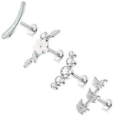 three pairs of white opal and crystal stud earrings with cross design on each ear