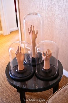 three wooden hands under glass on top of a table