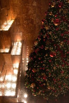 a lit christmas tree in the middle of stairs