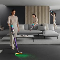 two women are using vacuums to clean the floor