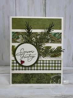 a handmade christmas card with pine branches and evergreen leaves on it, featuring the words season's greetings