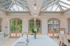 a kitchen with an island, sink and large glass windows in the ceiling above it