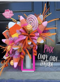 a pink candy corn halloween wreath on the front door