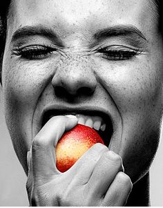 a man is biting into an apple with his mouth wide open