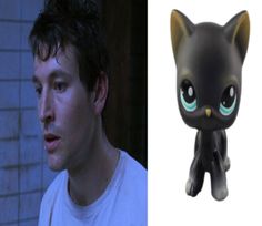 a black cat figurine next to a photo of a man with blue eyes