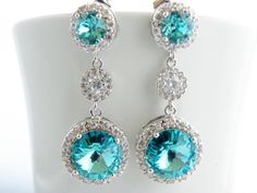 "Handmade Sterling Silver Earrings feature sparkly Light Turquoise Swarovski crystals that are set in frames designed and made exclusively for Estylo Jewelry. These beautiful earrings are made of Crystallized Elements drops that hang from Sterling post earrings with matching Turquoise Swarovski crystals surrounded by tiny clear Cubic Zirconia stones and round cubic zirconia connectors. They are perfect for a wedding or any other special occasion. They are gorgeous as focal point of your outfit. Blue Bling Jewelry For Wedding, Blue Bling Wedding Jewelry, Blue Rhinestone Crystal Earrings For Wedding, Turquoise Earrings For Wedding, Elegant Turquoise Bridal Earrings For Wedding, Light Blue Ocean, Bridal Dangle Earrings, Turquoise Bridesmaid, Blue Beach Wedding