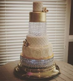 a three tiered cake sitting on top of a table in front of a window